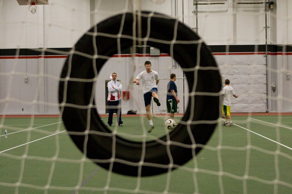 kicking a ball through a tire