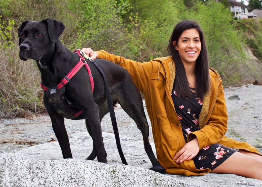 Amya C. - Recreation Lead, with her dog on a rock