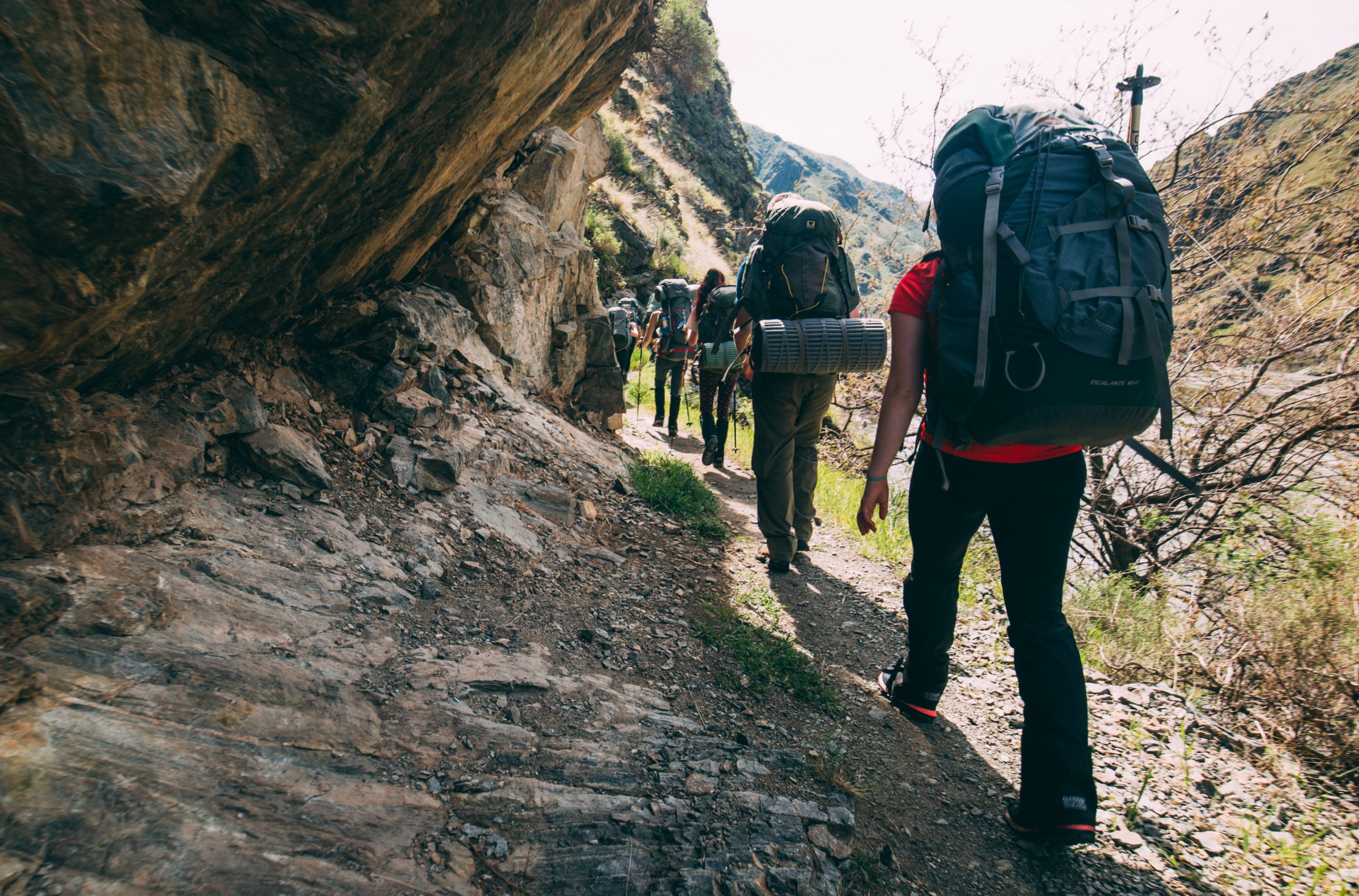 Walking through a hiking trail by a cliff face