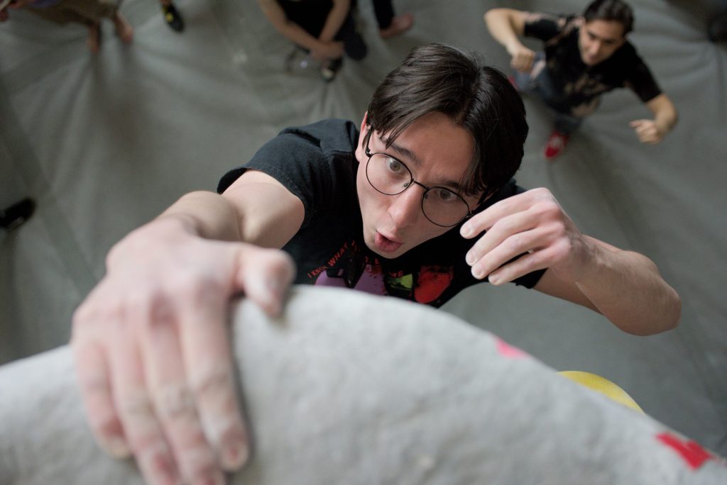 Rock Climber one handed a rock