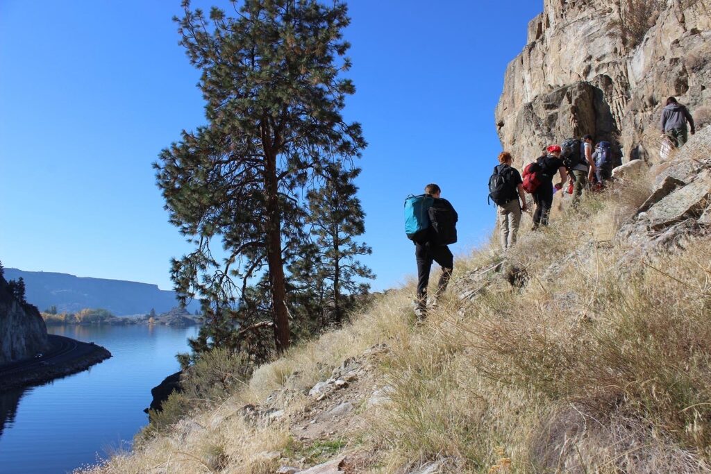 Hikers hiking up to a cliff side