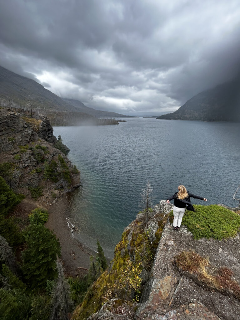 Allie T. - Field Staff, on top of a windy cliff ledge