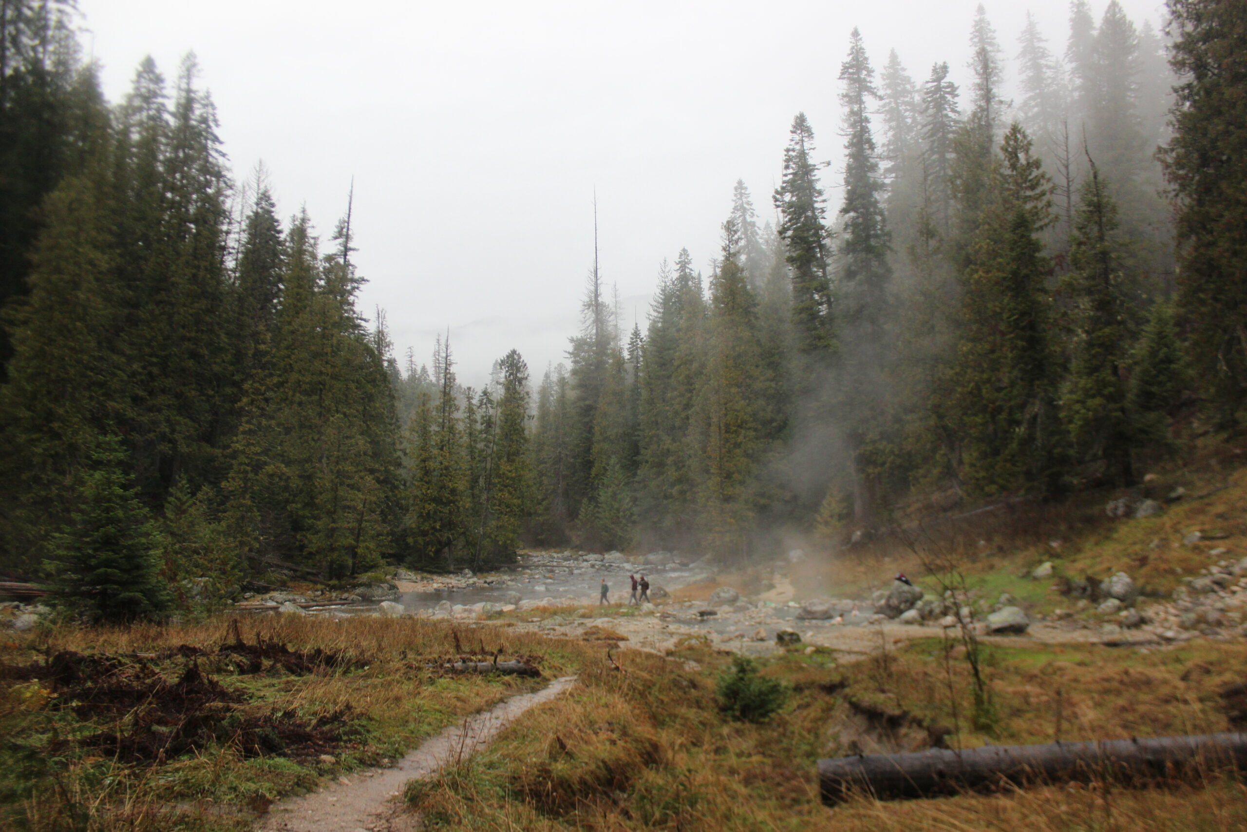 Hikers walking past a lake in the early morning