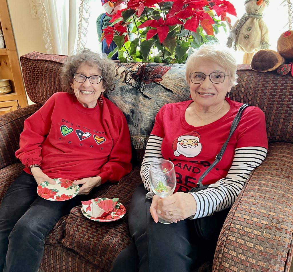 Two people, sitting, smiling at the camera