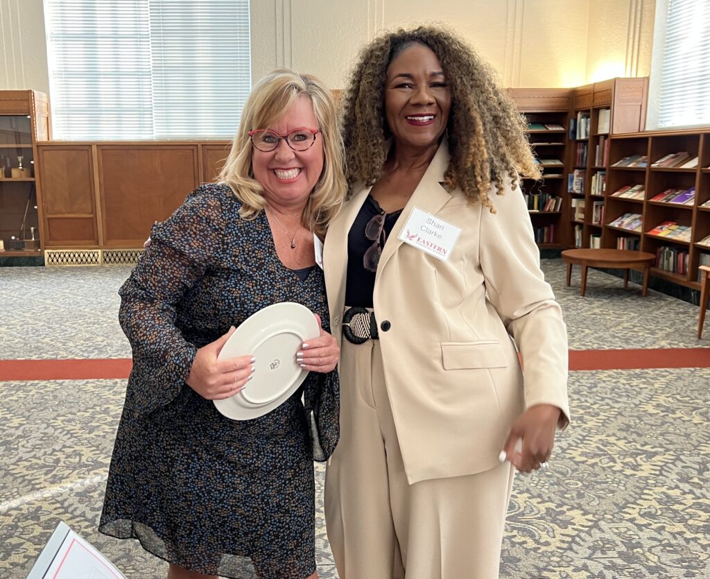 Two people pose for a picture, one with a plate