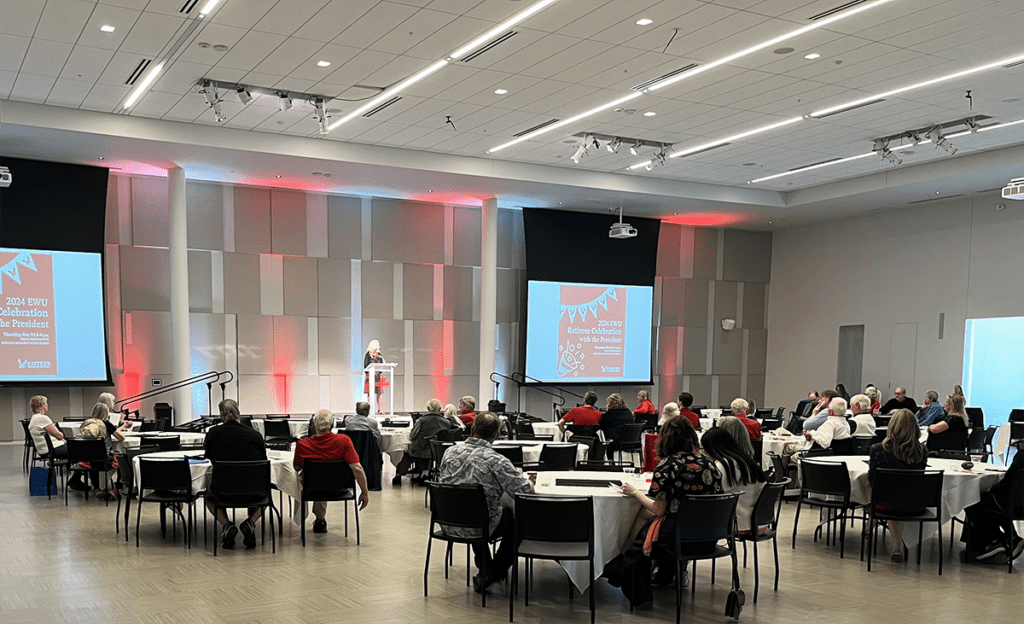 A photo of a speaker and listeners looking on to the stage
