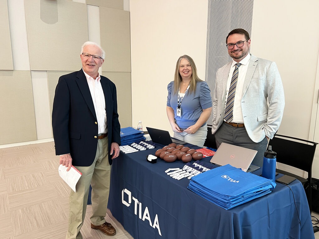 Two people standing behind a table advertisement