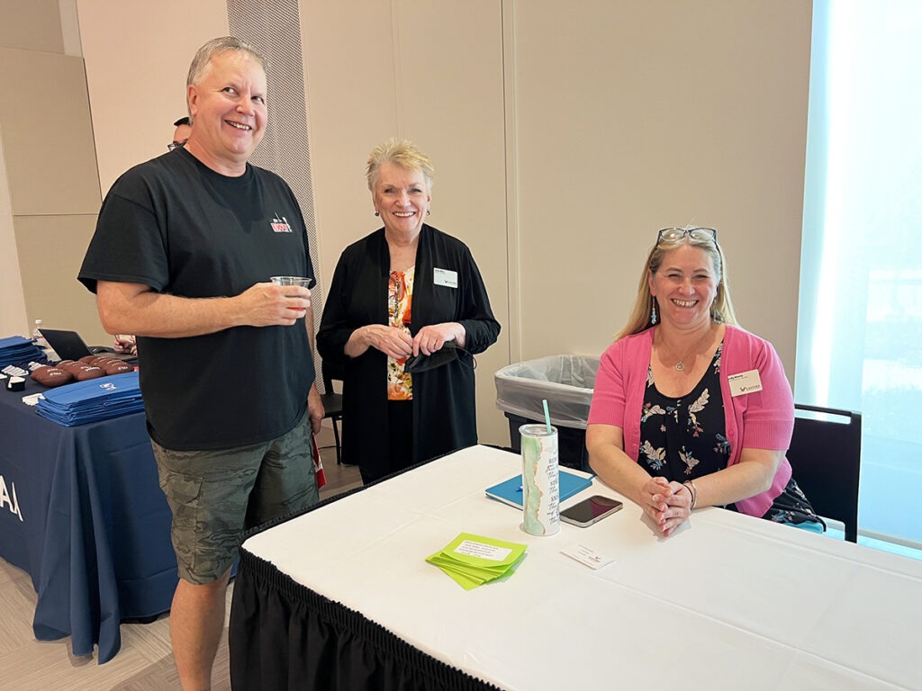 A photo of a person sitting and two people standing