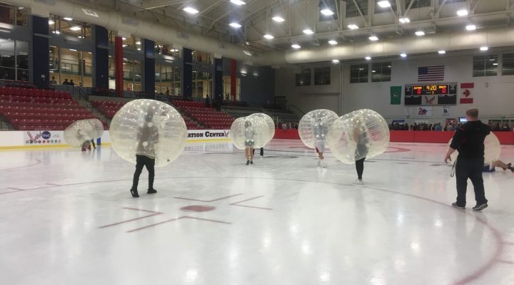 Students in the EWU ice rink wearing giant bubbles playing bubble soccer