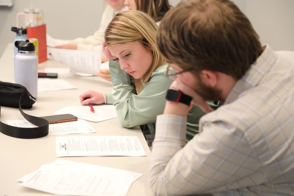 Two students at a table working together on a document.