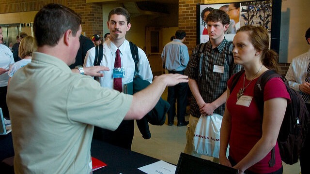 photo of students conversing There is a man and woman talking in front of two other men