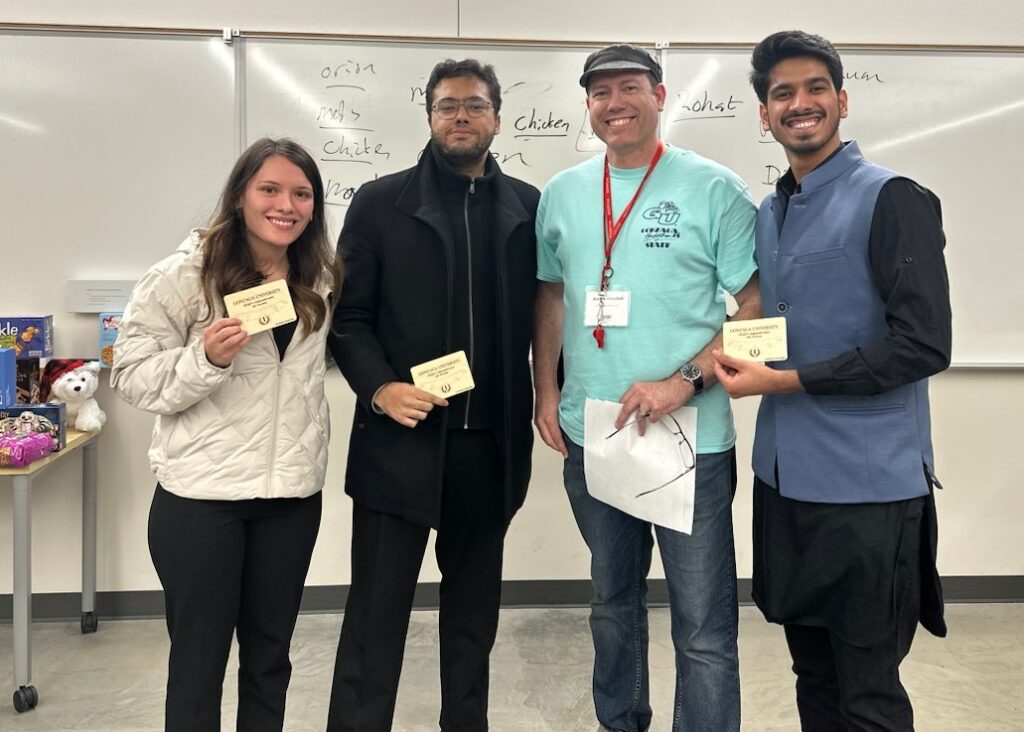 Photo of three winning students with a professor.