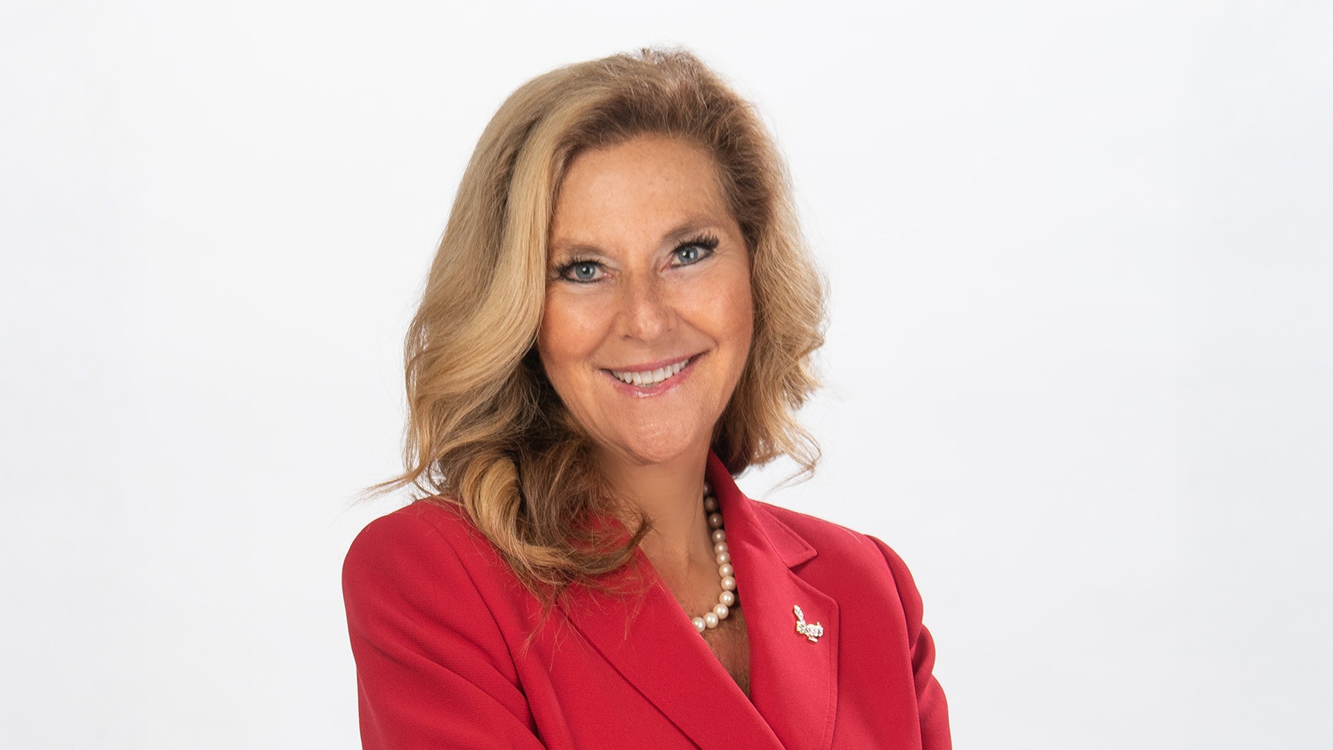 President McMahan portrait. She is wearing red with an Eagle pin.